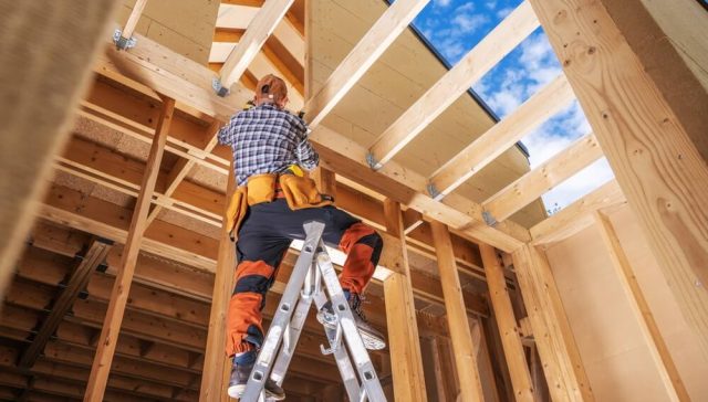 Trabajador construyendo la estructura de una casa económica en Estados Unidos.
